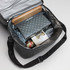 A cooler bag in grey, filled with a cheese set, rolling pin, and assorted gourmet items. Includes a logo.