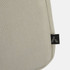 A beige laptop bag with a textured fabric, featuring a small logo tag on the side.
