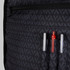 A black backpack interior featuring multiple pockets, including three pen holders and a zippered compartment.