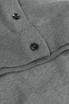 A grey cardigan featuring a buttoned collar and ribbed detailing. It has a branding logo on the fabric.