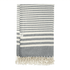 A grey and white striped blanket with tassel detailing, featuring a small logo tag.