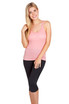 A pink women's singlet with a scoop neckline, worn with black capri leggings, featuring a branding logo.