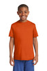 A youth in an orange Sport-Tek PosiCharge Competitor Tee stands smiling, wearing blue shorts. The shirt features a logo. A youth in an orange Sport-Tek PosiCharge Competitor Tee stands smiling, wearing blue shorts. The shirt features a logo.