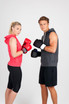 A red sleeveless hoodie worn by a woman and a grey sleeveless hoodie worn by a man, both holding boxing gloves.