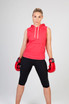 A woman wearing a red sleeveless hoodie and boxing gloves, standing confidently in a fighting stance.