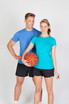 A blue athletic T-shirt worn by a man and a turquoise T-shirt worn by a woman, both in sports attire with shorts.