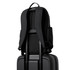 A black backpack rests on top of a black suitcase, with adjustable straps and side pockets visible. A black backpack rests on top of a black suitcase, with adjustable straps and side pockets visible.