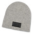 A grey cable knit beanie with a patch on the front, featuring ribbed texture and a rounded top.