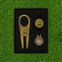 A gold magnetic golf tool set with a carabiner, including ball markers, arranged in a black box.