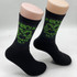 Black socks featuring a green design and branding on the upper part. The socks have a ribbed texture.