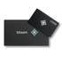 A black packaging box with a silver logo and a card featuring a design and the word "bloom."