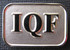 A silver lapel pin with a rectangular shape featuring the letters "IQF" in a bold font.