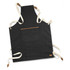 A dark grey canvas apron with cream straps and a front pocket, featuring a small logo.