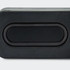 A rectangular black bass speaker featuring a smooth surface and a central oval design element.