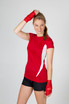 A red women's T-shirt with a white design, paired with red wrist wraps and black shorts. Features a logo on the shirt.