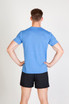A man wearing a blue heather t-shirt and black shorts, standing with his hands on his hips.