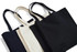 A set of three tote bags in black and cream, featuring sturdy handles and a simple design. One bag is smaller than the others.