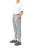 Grey three-layer cotton track pants with side pockets and a drawstring waist, paired with a white T-shirt and sneakers.