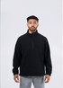 A black polar fleece half zip top with long sleeves and side pockets, featuring a branding logo.