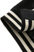Close-up of the collar of a black varsity jacket with cream stripes along the ribbed edges and a branding logo.