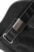 A close-up of a black cotton drill cap featuring a metal adjustment buckle and strap.