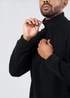 A black polar fleece half zip top with a high collar and a zipper, featuring a person adjusting the zip.
