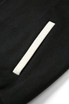 A close-up of a black wool blend soft shell varsity jacket featuring a white pocket detail and a logo.