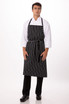 A black and white striped chef apron worn by a model, featuring a logo on the front.