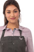 A dark grey Dorset Bib Apron worn over a checked shirt, featuring a pocket and a metal ring detail.