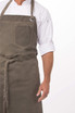 A dark olive green chef's bib apron with a pocket, featuring a classic design and a logo.