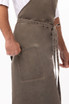 A grey chef's bib apron with a pocket, featuring ties at the waist and a casual, textured finish.