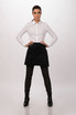A model wearing a black Largo Half Bistro Apron over dark pants and a white shirt, standing against a neutral background.