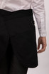 A black half bistro apron with a pocket and strap detail, worn by a person in a white shirt.
