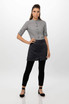 A model wearing a grey shirt and a black half bistro apron, paired with black leggings and flats.