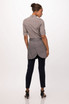A grey half bistro apron worn over a striped shirt, paired with dark trousers and high-heeled shoes.