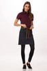 A bistro apron in a dark denim colour, featuring a brown tie and pockets, styled with a maroon shirt and black pants.