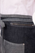 A half bistro apron in shades of dark grey with a front pocket and a zippered pocket on the side.