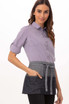 A woman wears a Manhattan Waist Apron featuring various shades of denim, complete with pockets and a tied waist.