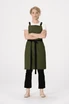 A green cross back apron with black straps, modelled by a person wearing a white t-shirt and black pants.