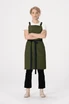 A green Lockharte cross back apron with black straps, worn by a model standing with arms crossed.