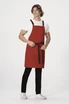 A red cross back apron with black straps, worn by a model against a plain background.