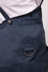 A navy blue Largo Bib Apron featuring a side pocket with a metal ring and adjustable straps.