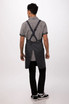 A dark grey Largo Bib Apron worn by a person, featuring adjustable straps at the back.