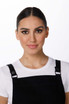 A model wearing a black Byron Cross-Back Apron over a white t-shirt, featuring a logo on the apron.