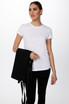 A woman in a white t-shirt holds a black Byron Cross-Back Apron. The apron features long ties for fastening.
