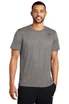 A man wearing a grey Nike T-shirt stands smiling, with a logo on the chest and black pants.