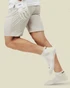 Custom branded golf socks in white, worn by a person in beige shorts, showing a playful running pose.