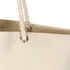A cream-coloured tote bag featuring rope handles and a metal eyelet. It includes a logo on the front.