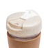 A reusable coffee cup featuring a cork band, with a lid made from a sustainable material that has a speckled design.