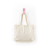 A natural cotton tote bag in a soft cream colour, hanging by its straps on a pink hook.